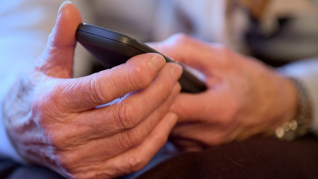 Eine ältere Frau hält ein Telefon in den Händen (Foto: picture alliance / Britta Pedersen/dpa-Zentralbild/dpa)