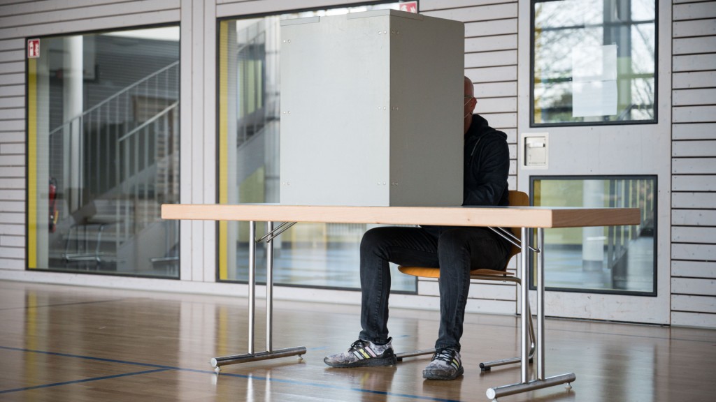 Foto: Ein Mann wählt in einem Wahllokal (Foto: picture alliance/dpa/Oliver Dietze)