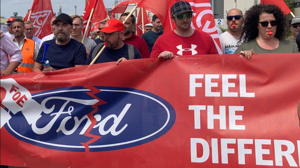 Foto: Zerrissenes Ford-Logo auf dem Banner von protestierenden Fordarbeitern