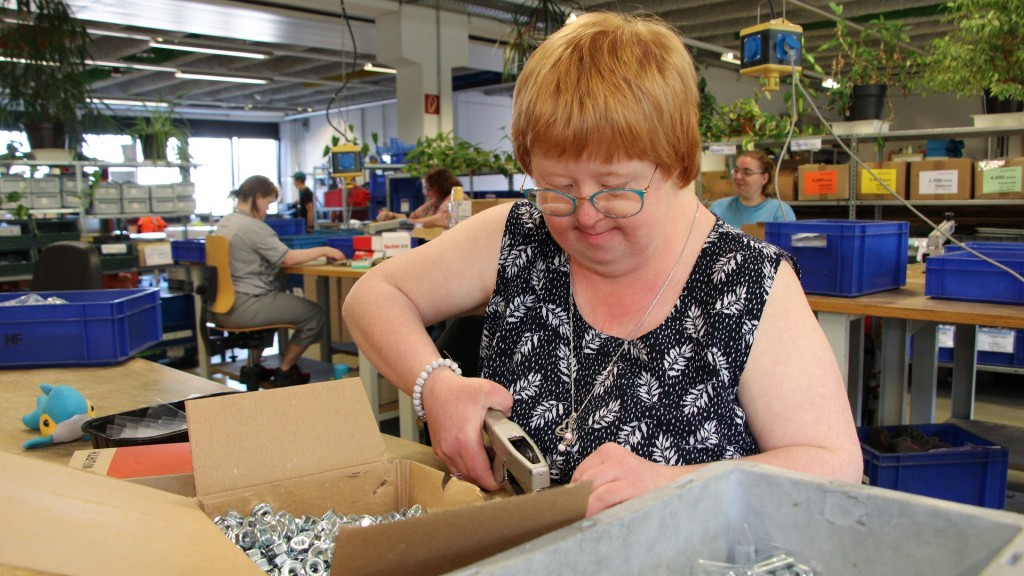 In einer Werkstatt in Bübingen werden Schrauben von einer Mitarbeiterin mit Behinderung verpackt und sortiert  