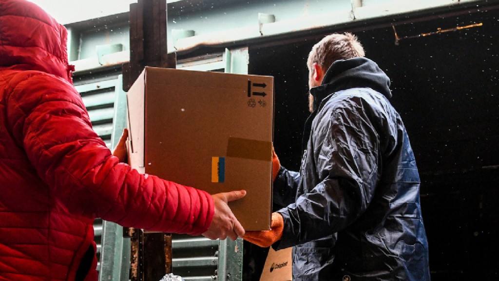 Personen transportieren Kartons mit humanitären Hilfsgütern