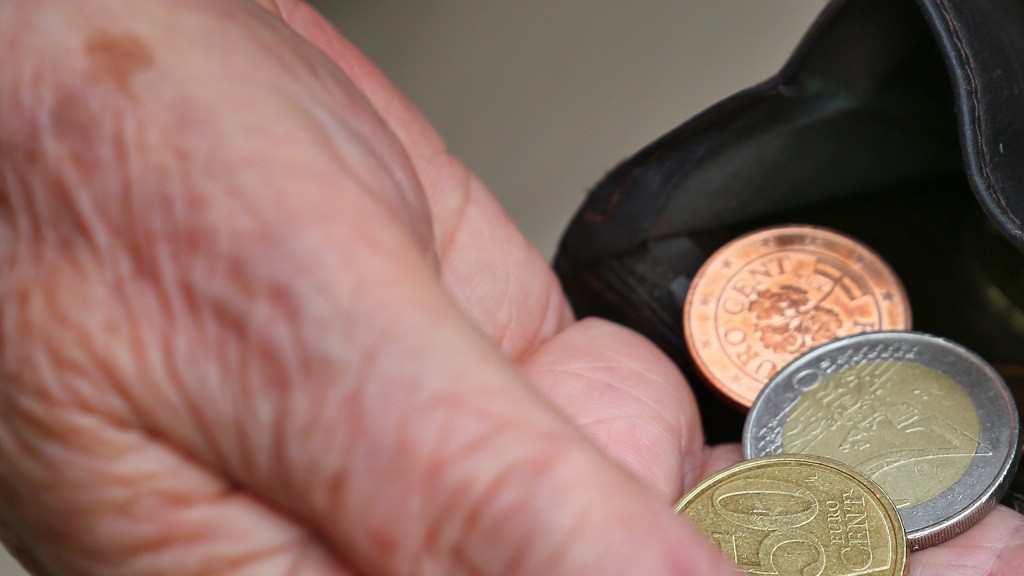 Foto: Eine Rentnerin hält einen Geldbeutel mit verschiedenen Euromünzen in ihrer Hand
