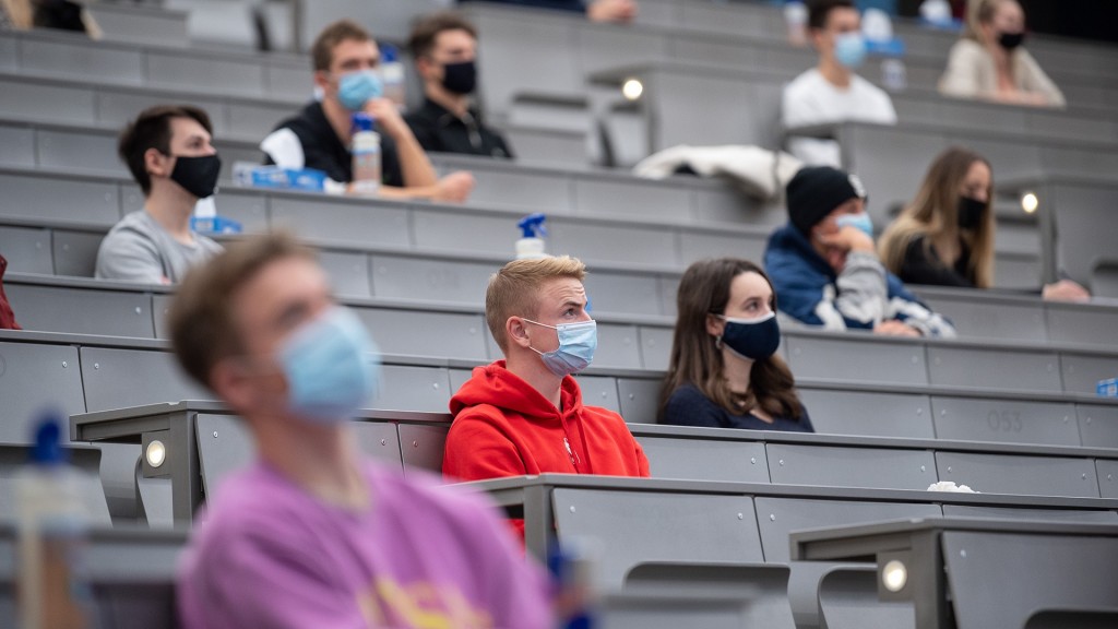 Studenten sitzen mit Maske in einem Hörsaal