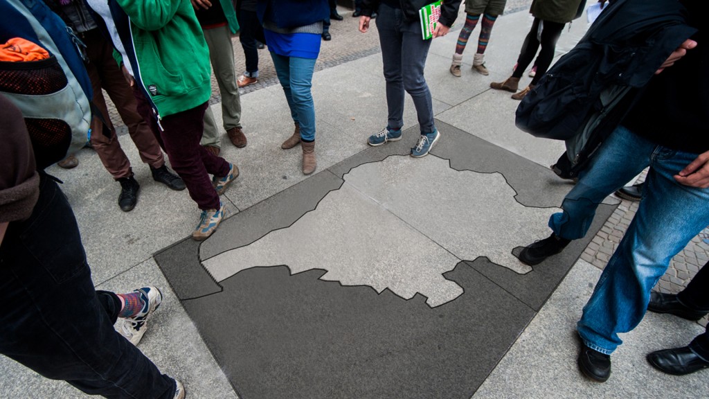 Menschen stehen um eine Saarlandkarte am Boden