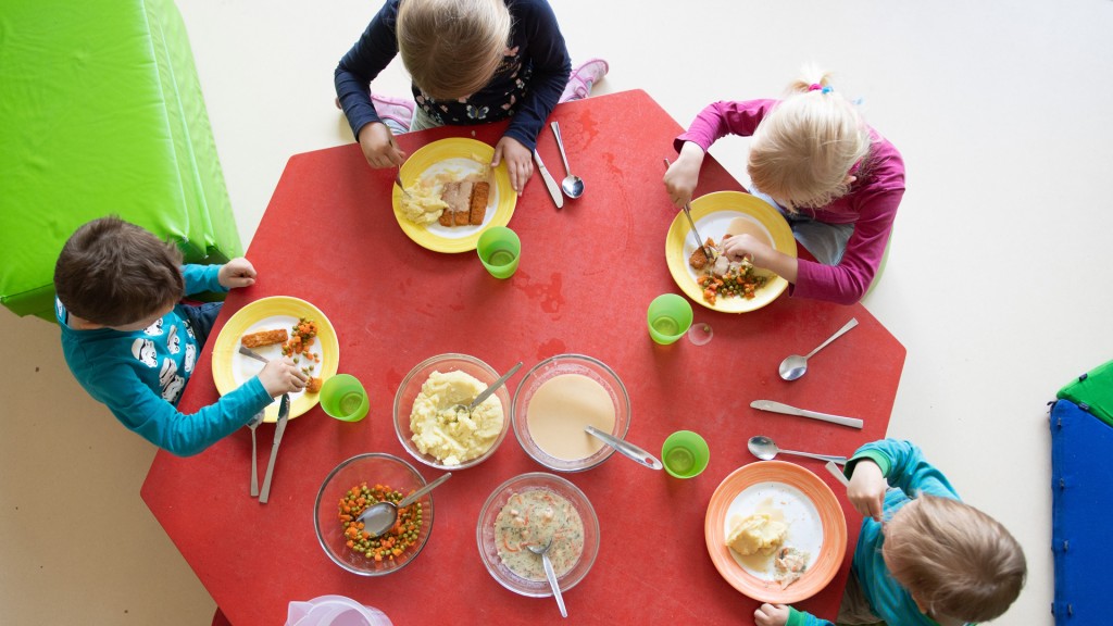 Foto: Kinder sitzen in einem Kindergarten während des Mittagessens an einem Tisch