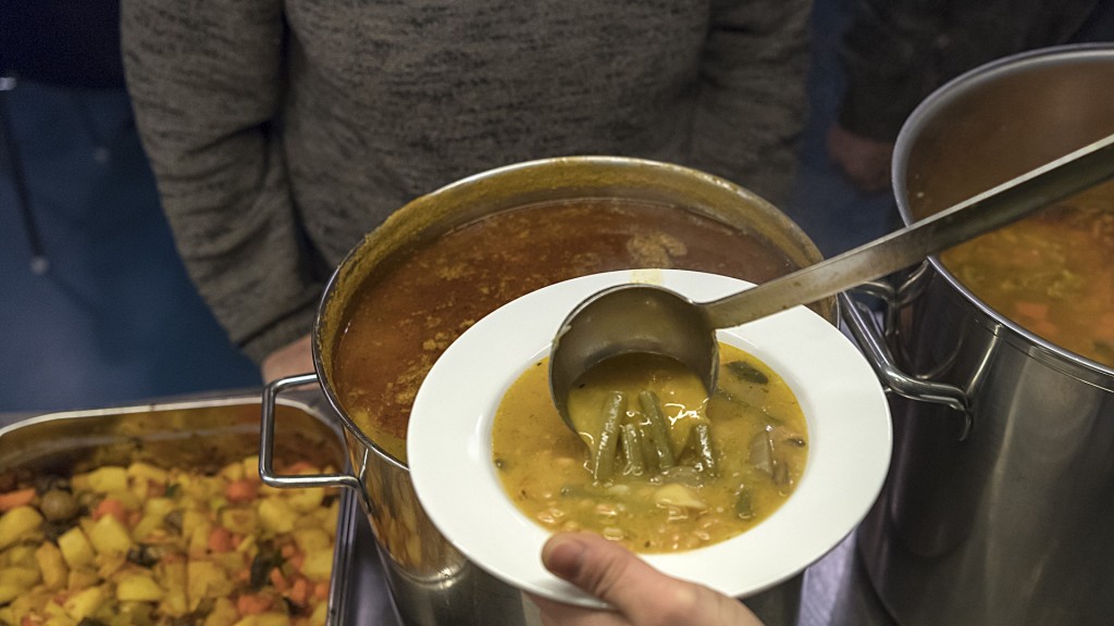 Eine warme Suppe wird an der Essensausgabe einer Wärmestube verteilt