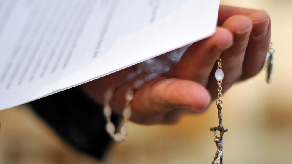 Foto: Rosenkranz in einer Priesterhand