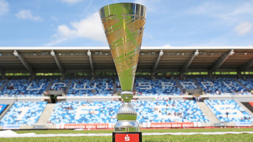 Die Trophäe des Saarlandpokals steht auf dem Spielfeld eines Fußballstadions