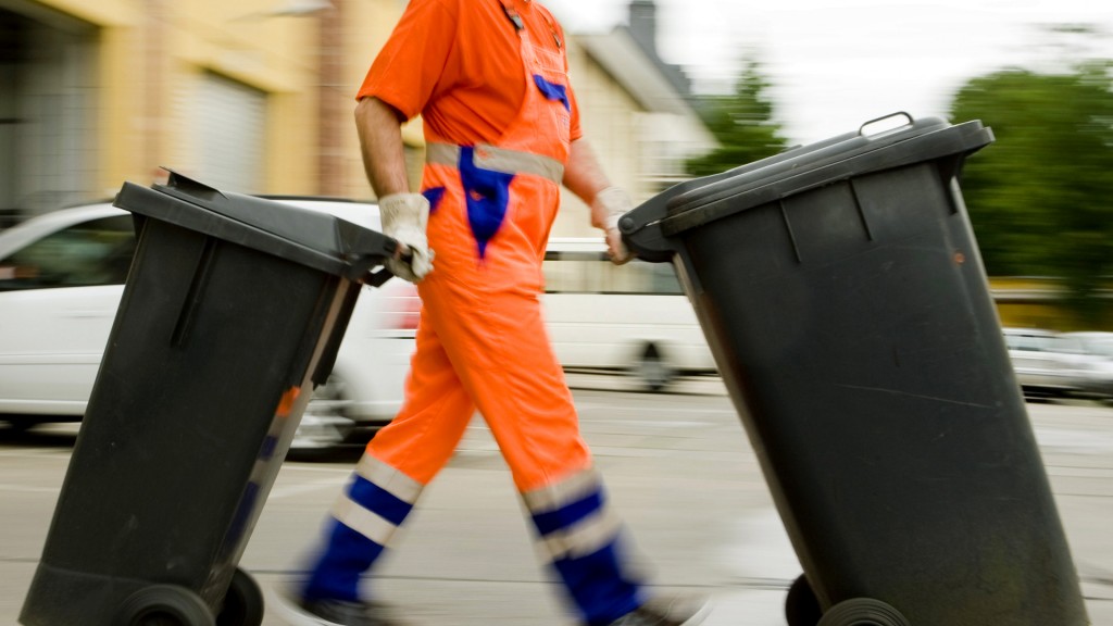 Ein Müllmann bringt Restmülltonnen weg