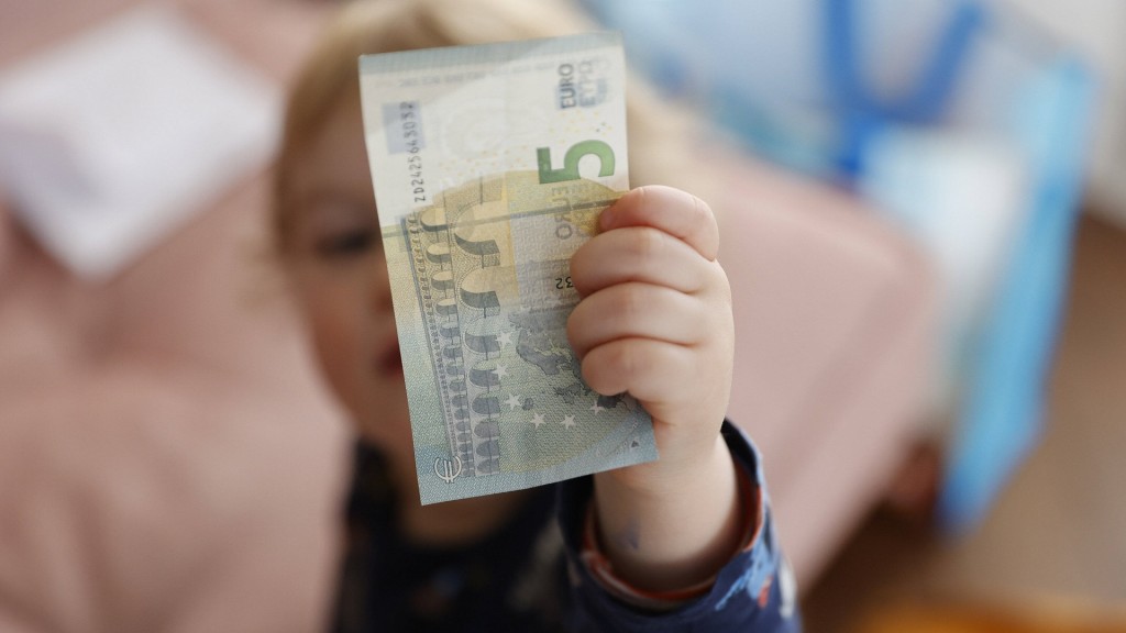 Ein Kind hält einen Geldschein in der Hand
