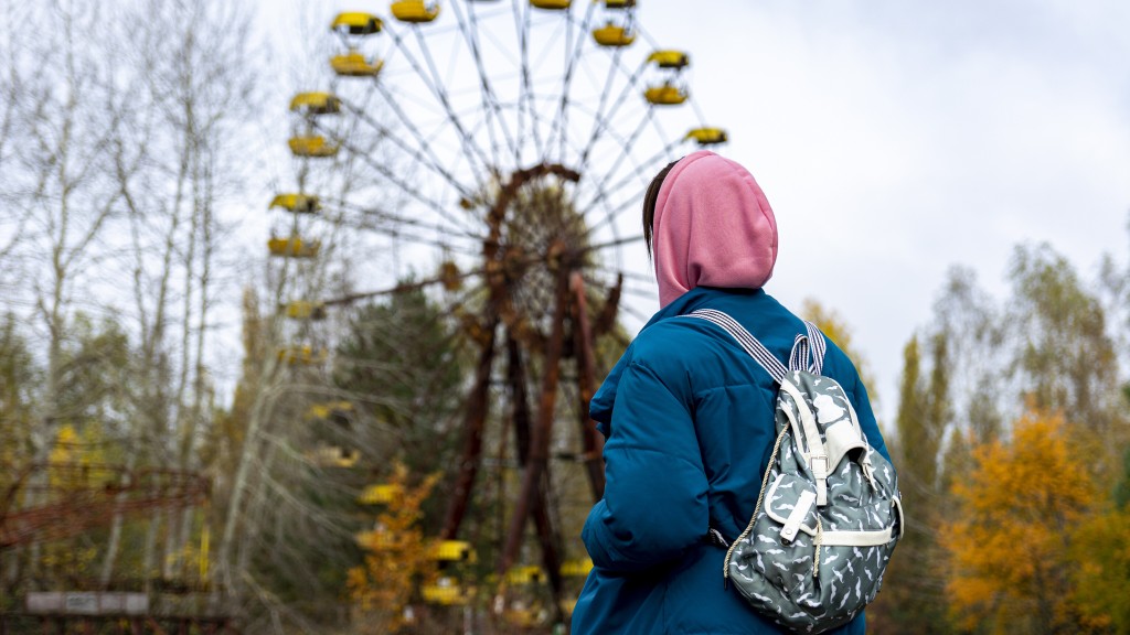 Eine Frau vor einem heruntergekommenen Riesenrad in Pripyat bei Tschernobyl.