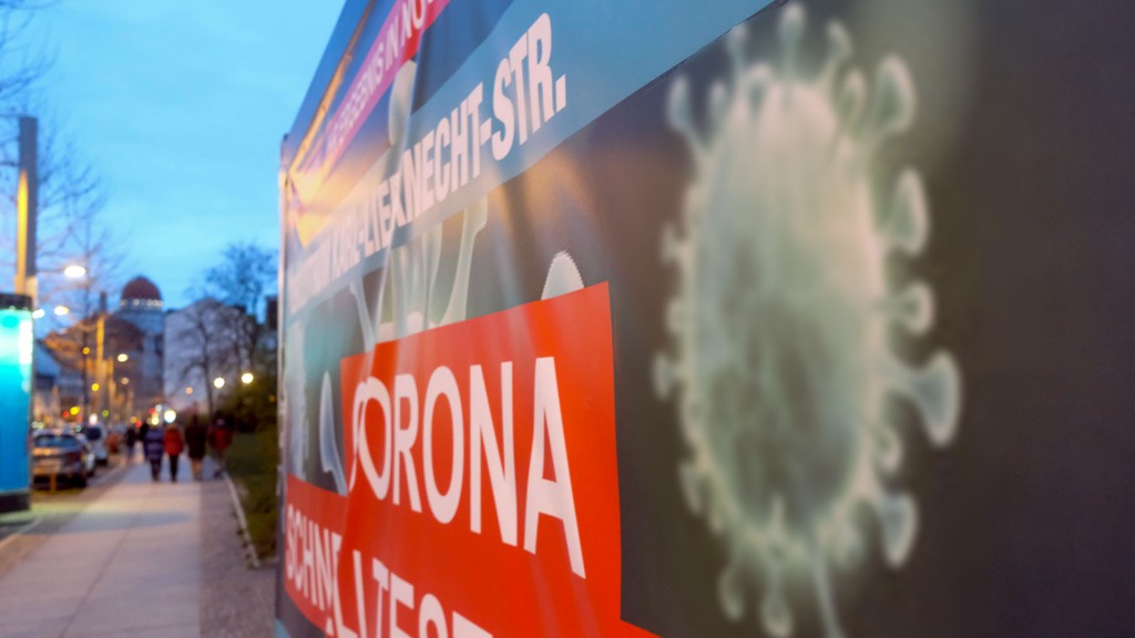 Foto: Abbildung eines Virus auf dem Banner eines Coronatestzentrums
