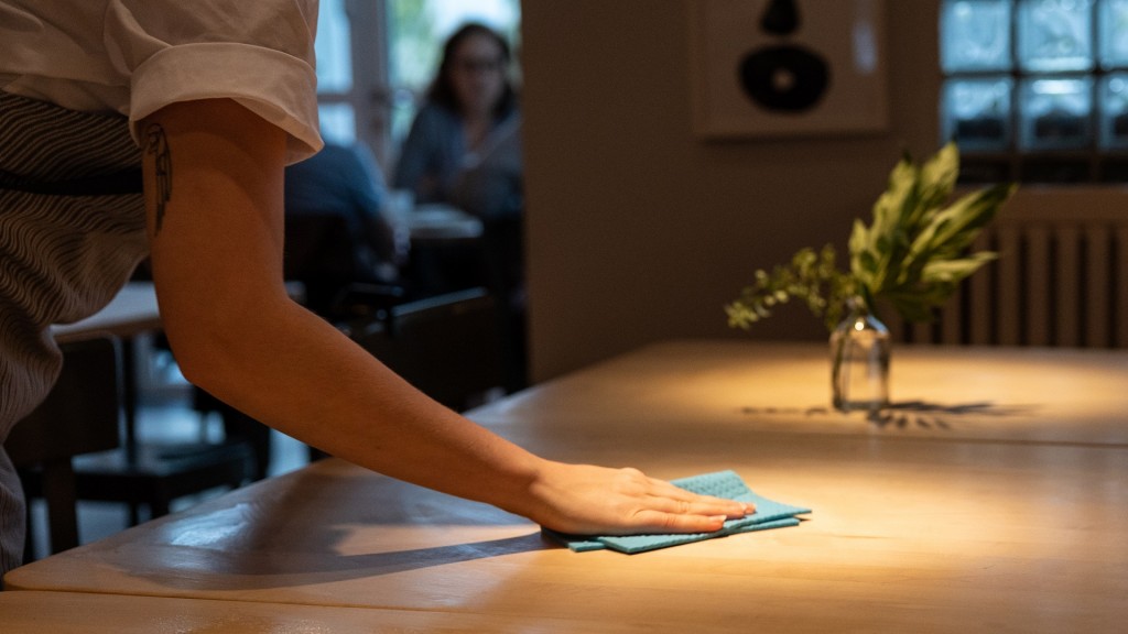 Foto: Eine Bedienung wischt einen Tisch im Restaurant sauber