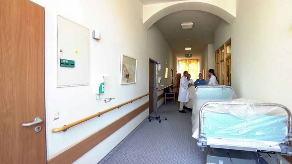 Foto: Medizinisches Personal steht neben einem Bett im Krankhausflur in der Merziger Klinik