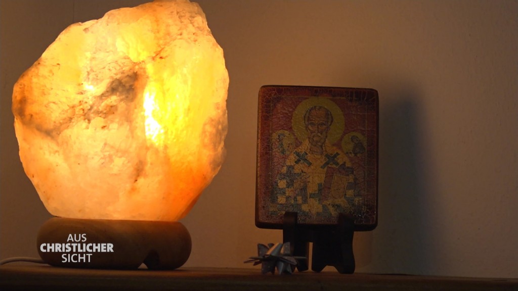 Foto: Ein Jesusabzeichen vor einer Salzlampe