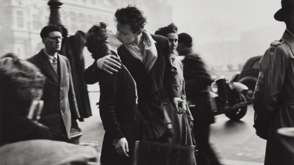 Foto: Eine schwarz-weiß Fotografie von zwei Liebenden, die sich in den Straßen von Paris küssen