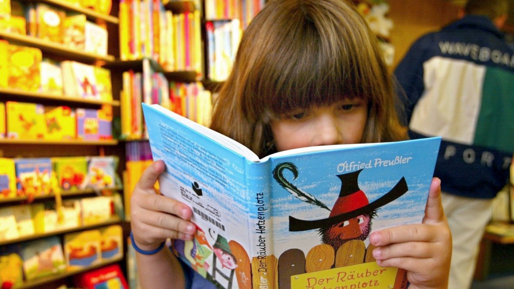 Ein Mädchen liest in dem Buch 'Räuber Hotzenplotz'