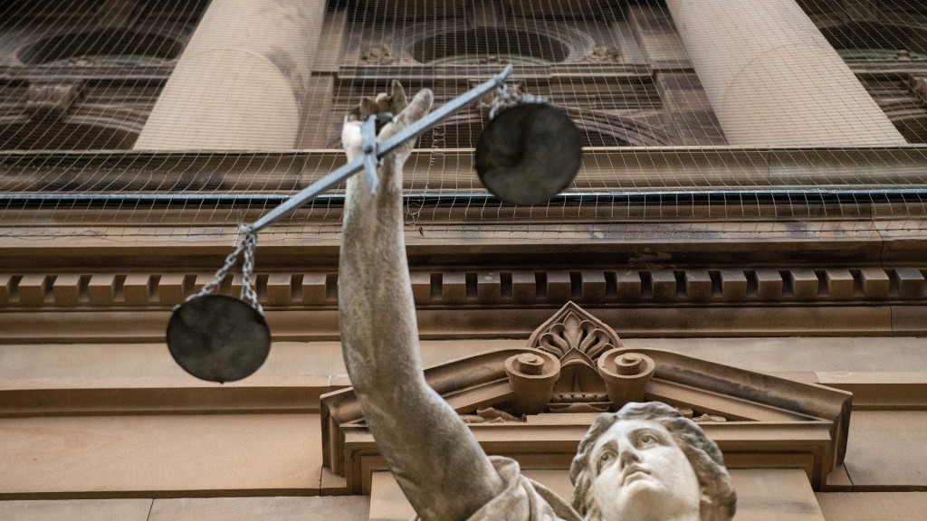 Foto: Eine Statue der Göttin Justitia vor einem Gericht