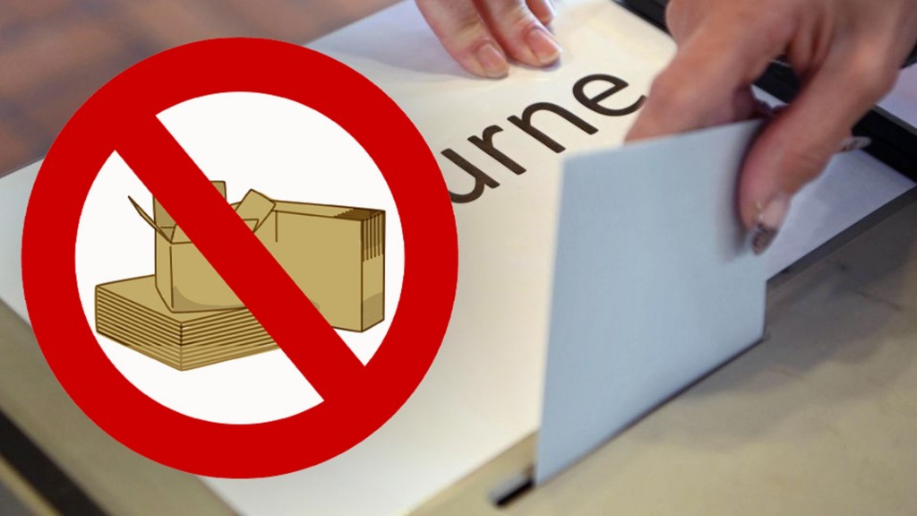 Ein Verbotsschild mit Umzugskarton über einer Wahlurne