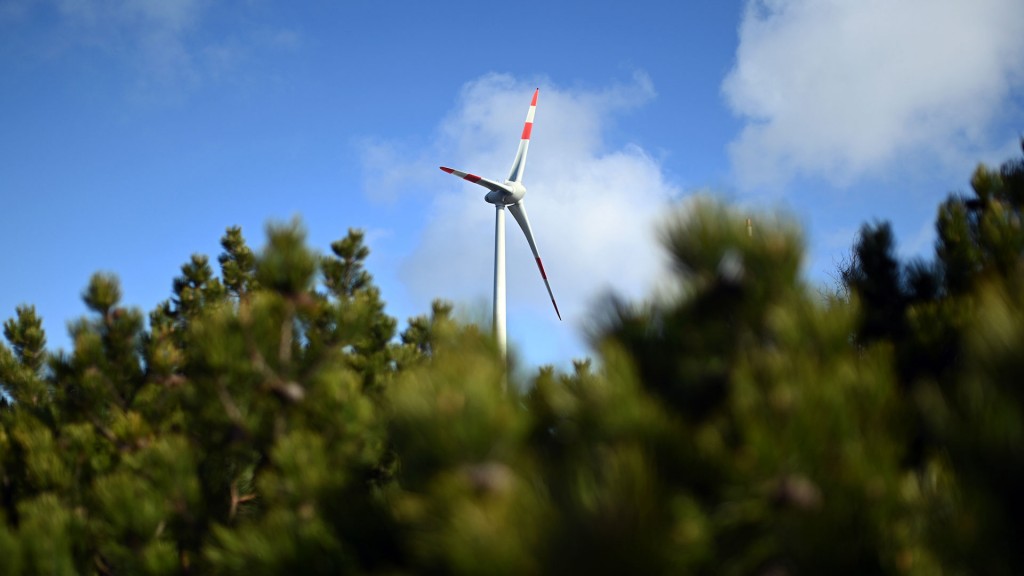 Eine Windenergie-Anlage steht nahe eines Waldes