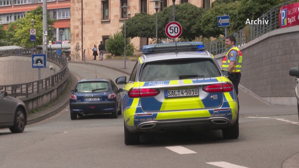 Foto: Polizeiauto mit einem Beamten auf einer Straße