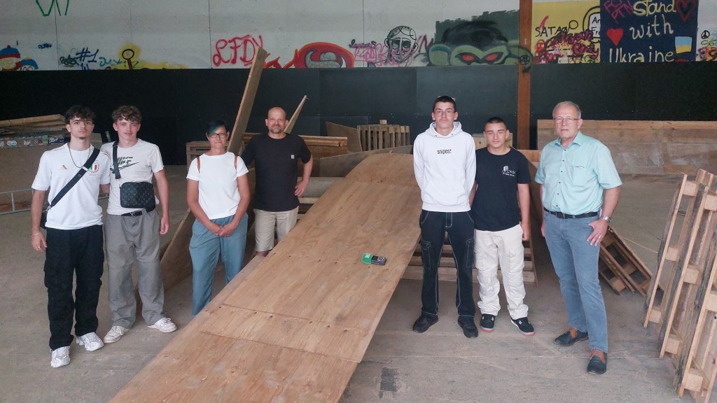 Das Team des JUZ Wiebelskirchen und Jugendliche in der zerstörten Skaterhalle 