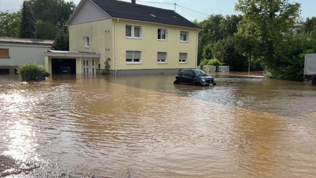 Foto: Geflutete Straßen und ein Auto zur Hälfte im Wasser