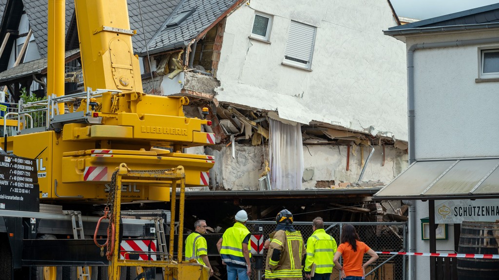 Foto: Ein LKW-Kran steht an einem teilweise eingestürzten Hotel im Rheinland-Pfälzischen Kröv um ein weiteres Absacken zu verhindern