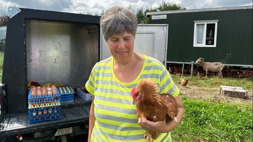 Claudia Maurer und ihr Huhn vor dem Stall