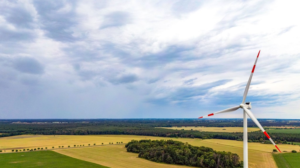 Eine Windkraftanlage steht zwischen Landwirtschaftlich genutzten Flächen