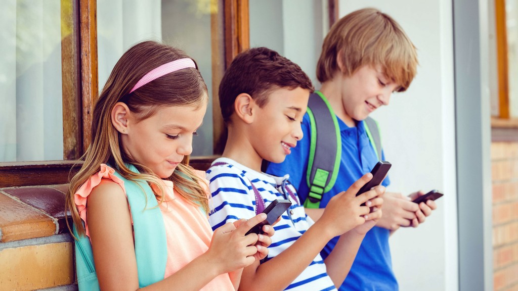 Foto: Grundschüler stehen zusammen mit ihren Smartphones