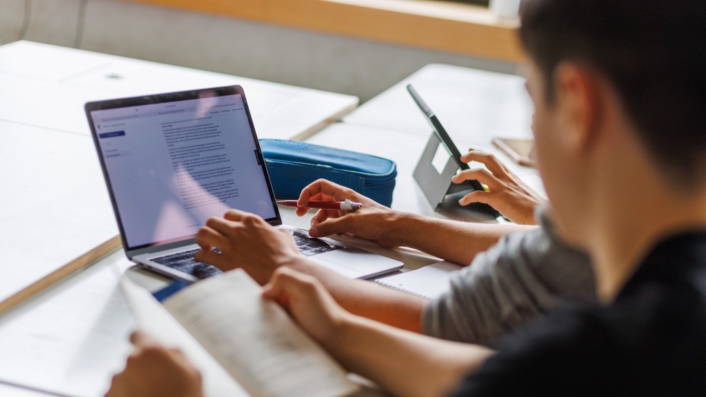 Schüler eines Gymnasiums sitzen vor einem Laptop in der Schule.