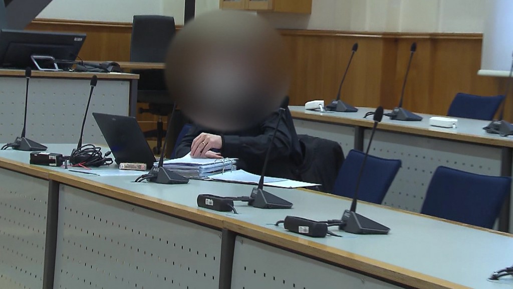 Foto: Angeklagter auf einer Prozessbank, Gesicht unkenntlich