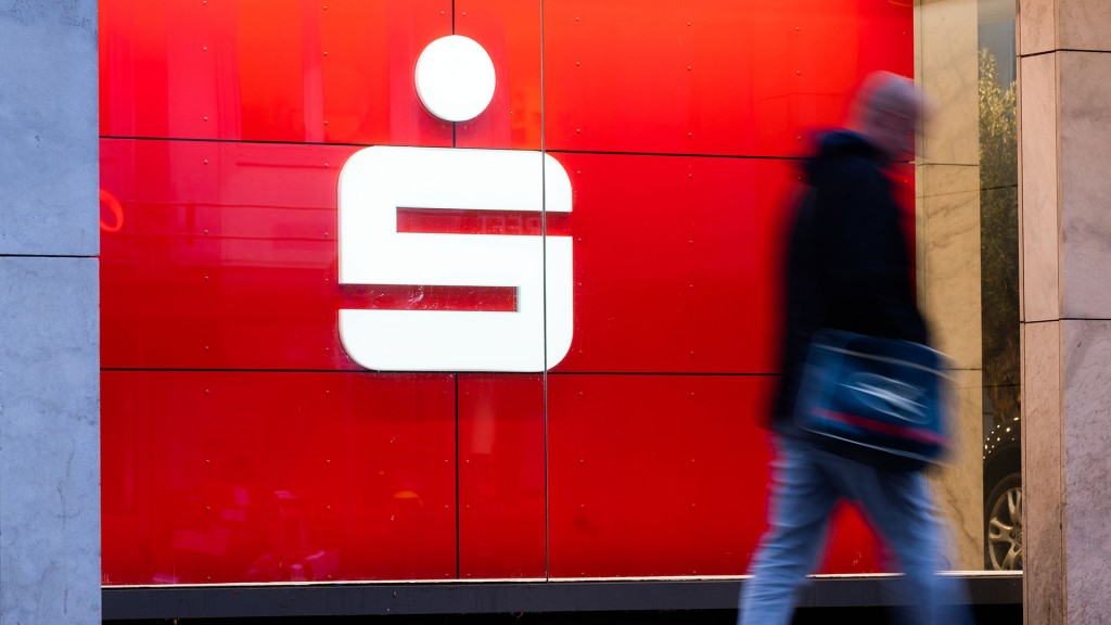 Passanten läuft an einer Filiale der Sparkasse vorbei