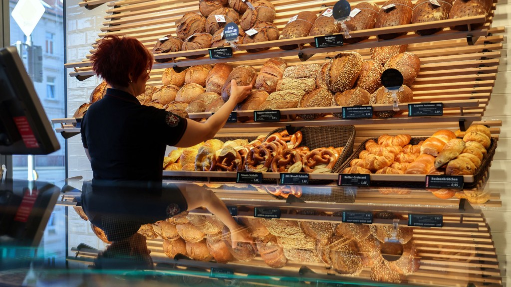 Foto: Eine Mitarbeiterin räumt Mischbrot in die Auslage einer Bäckerei