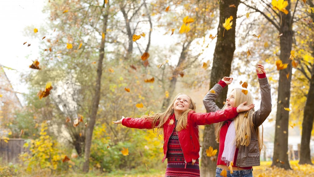 Zwei Mädchen spielen im Herbstlaub