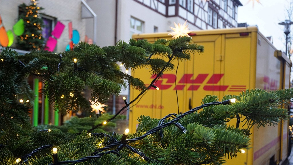 Ein Paketzustellfahrzeug von DHL steht hinter einem Weihnachtsbaum auf der Straße