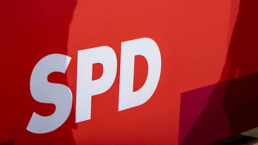 Personen werfen Schatten auf das Logo der SPD.