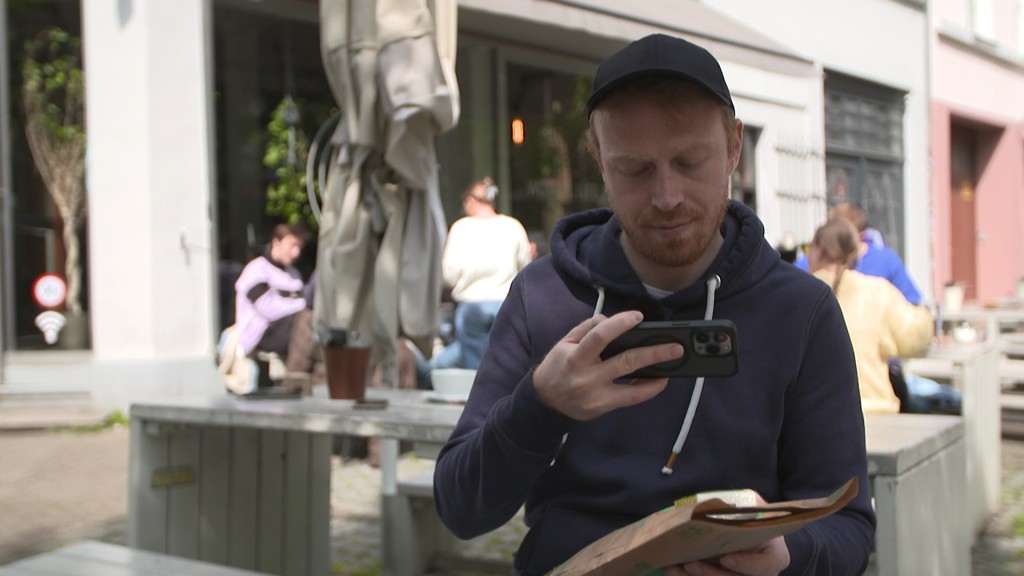Foto: Mann schaut auf sein Handy.