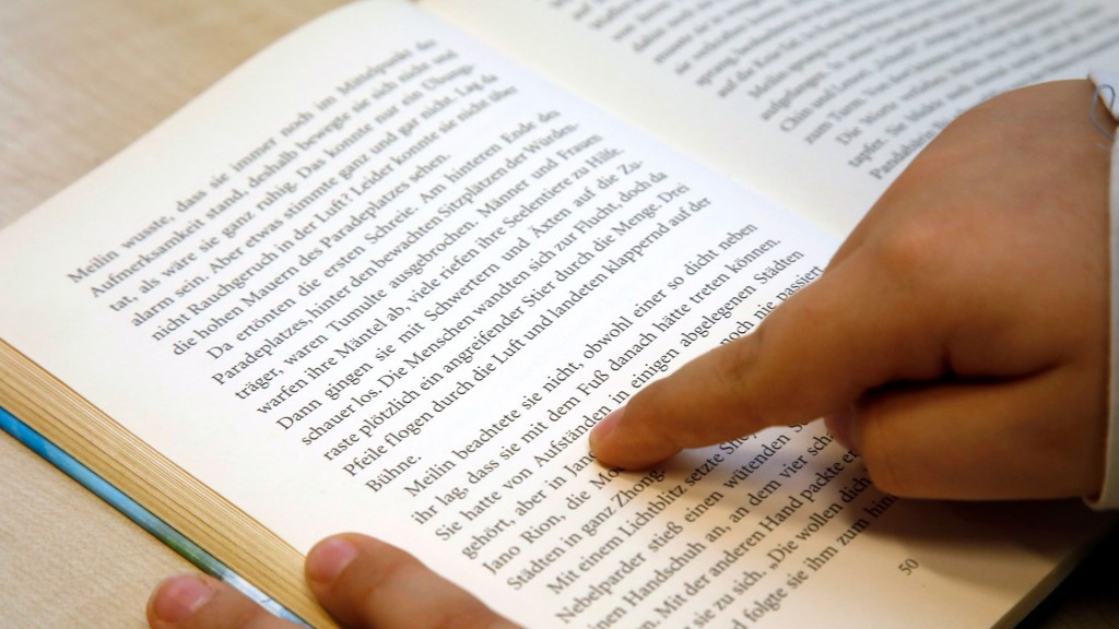 Foto: Ein Kind liest mit dem Finger im Buch