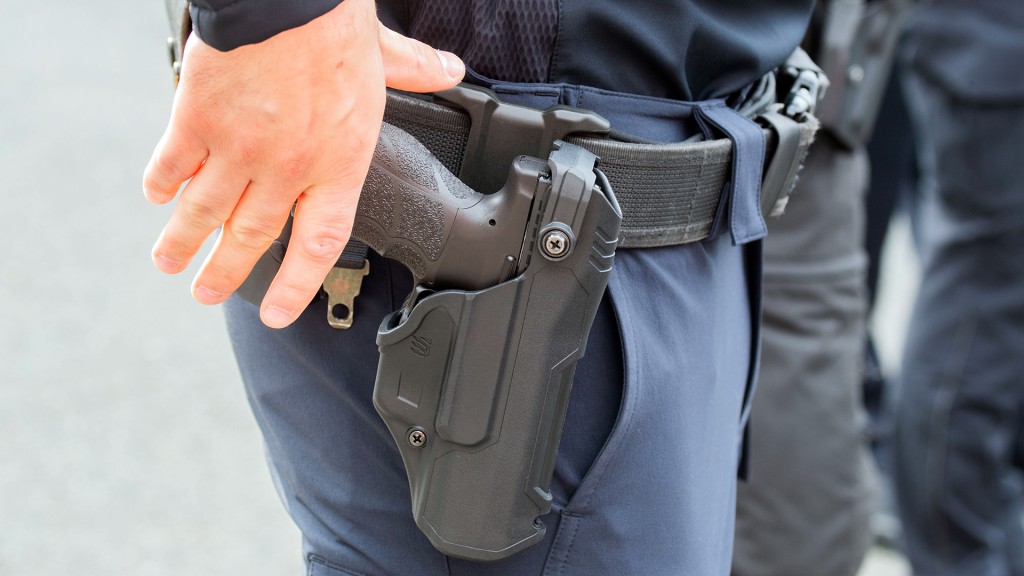 Ein Polizist greift nach seiner Dienstwaffe im Gürtelholster