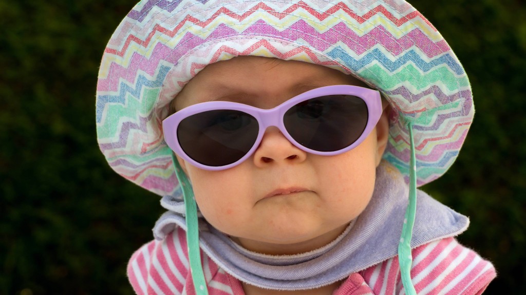 Ein Baby mit Sonnenbrille und Sonnenhut 