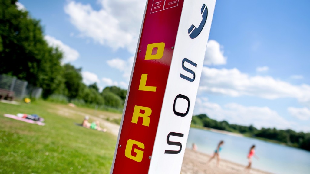 Eine Notrufsäule der DLRG steht an einem Badesee 
