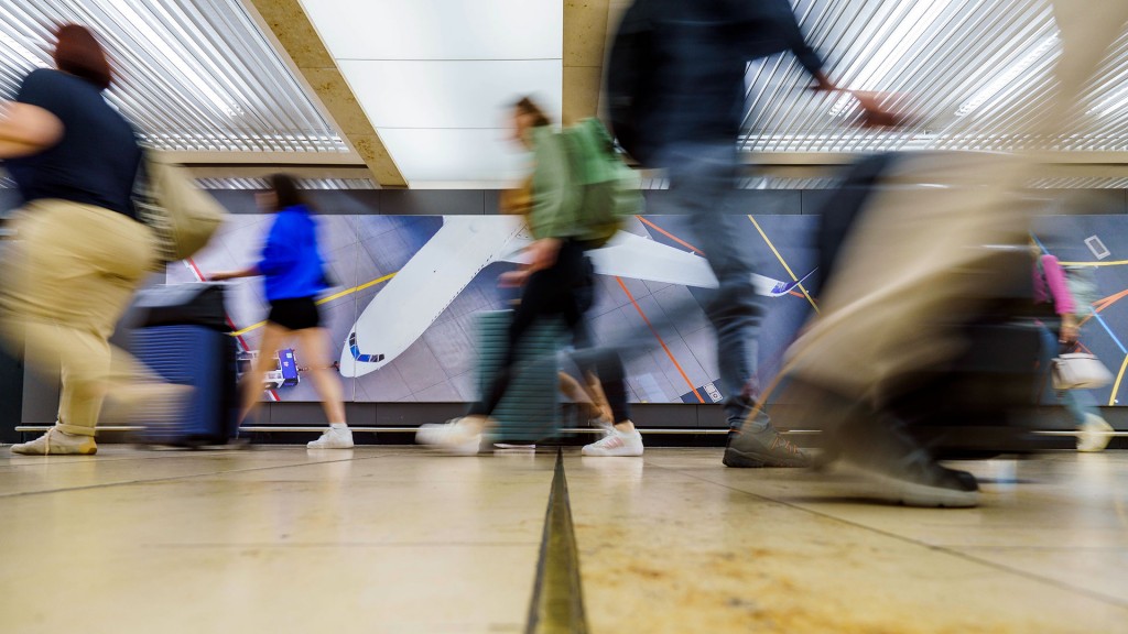 Reisende huschen mit ihrem Gepäck durch den Flughafen