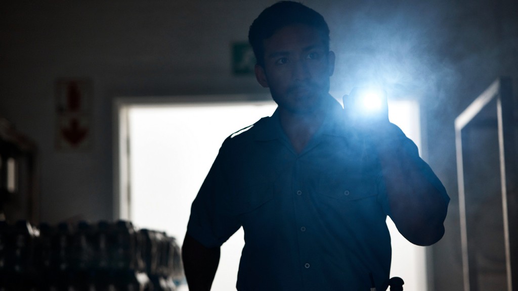 Jemand leuchtet mit einer Taschenlampe im dunklen Büro