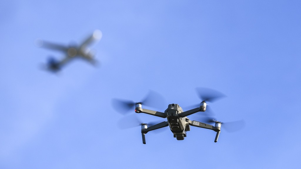 Eine Drohne fliegt am Himmel, im Hintergrund ist ein Flugzeug zu sehen.
