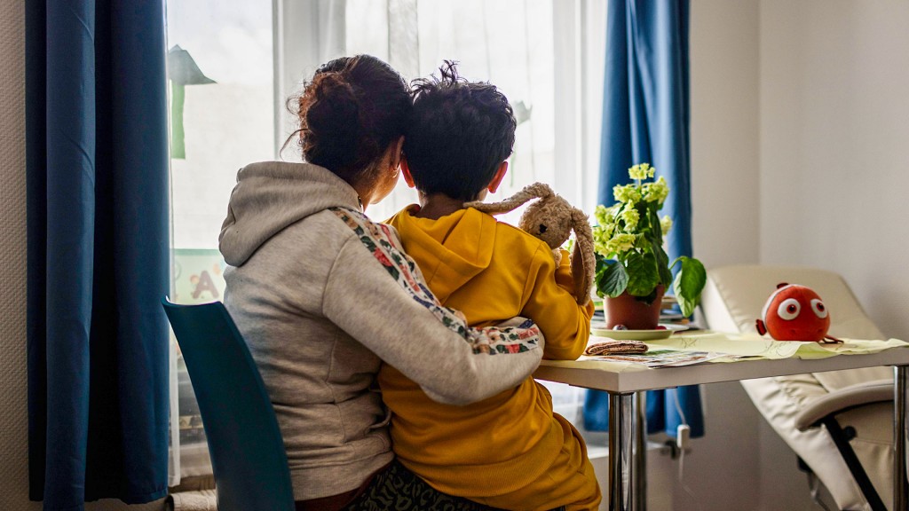 Foto: Eine Bewohnerin mit ihrem Sohn auf dem Schoß in einem Frauenhaus