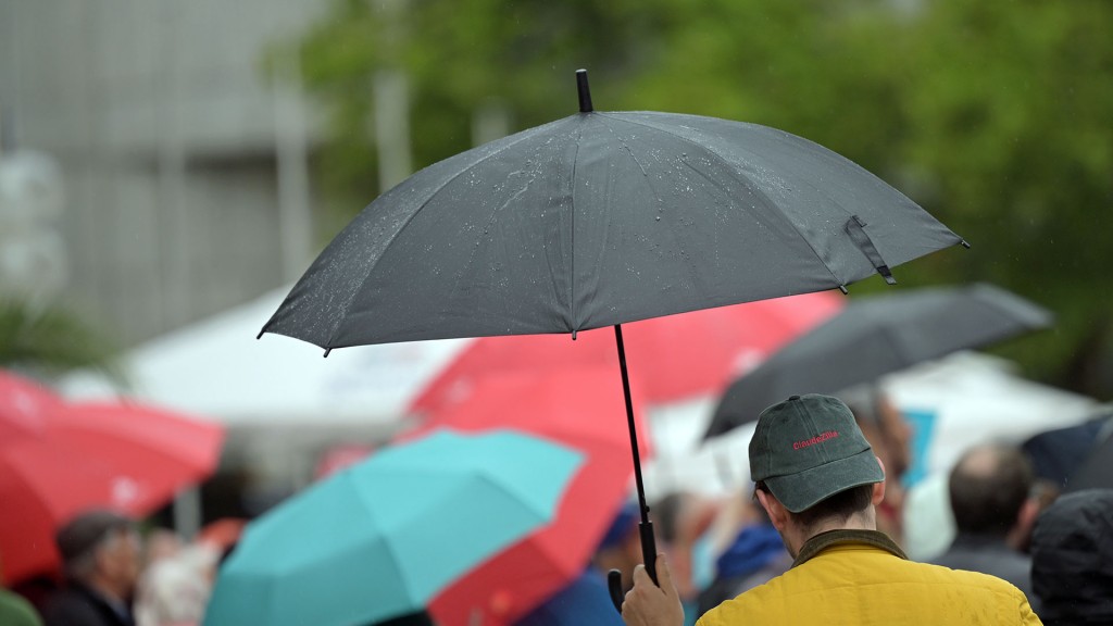 Foto: Passanten mit Regenschirmen in einer Fußgängerzone