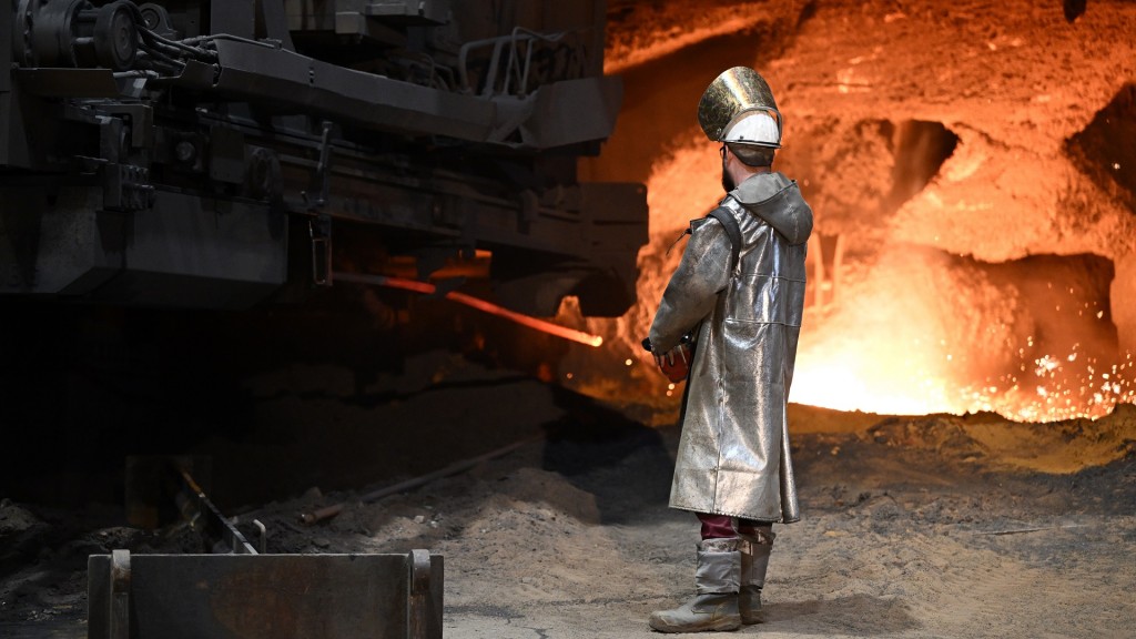 Foto: Ein Stahlarbeiter steht an einem Hochofen