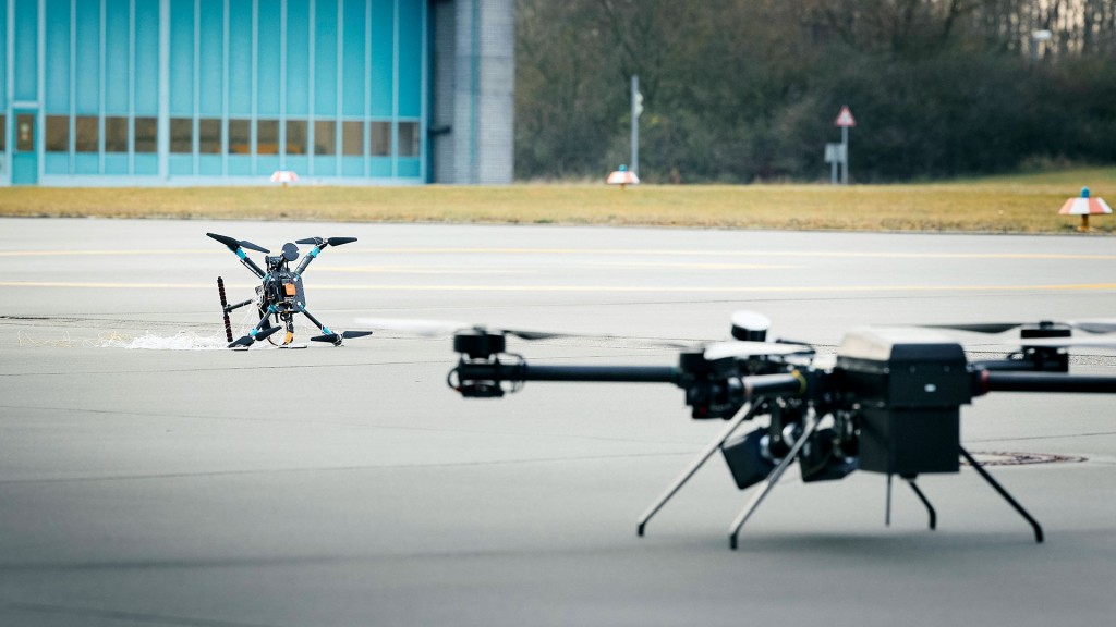 Foto: Eine Testdrohne und eine Abfangdrohne auf dem Boden vor einem Flugzeughangar